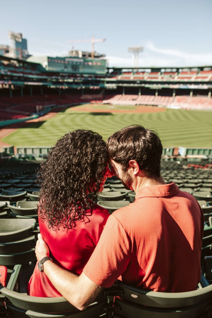 Couple poses in bleachers at Fenway Park for Boston engagement photos