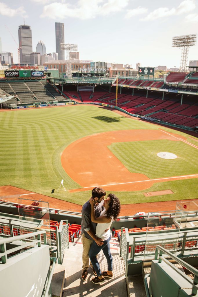 Couple walking the field at Fenway park during their Boston engagement photos