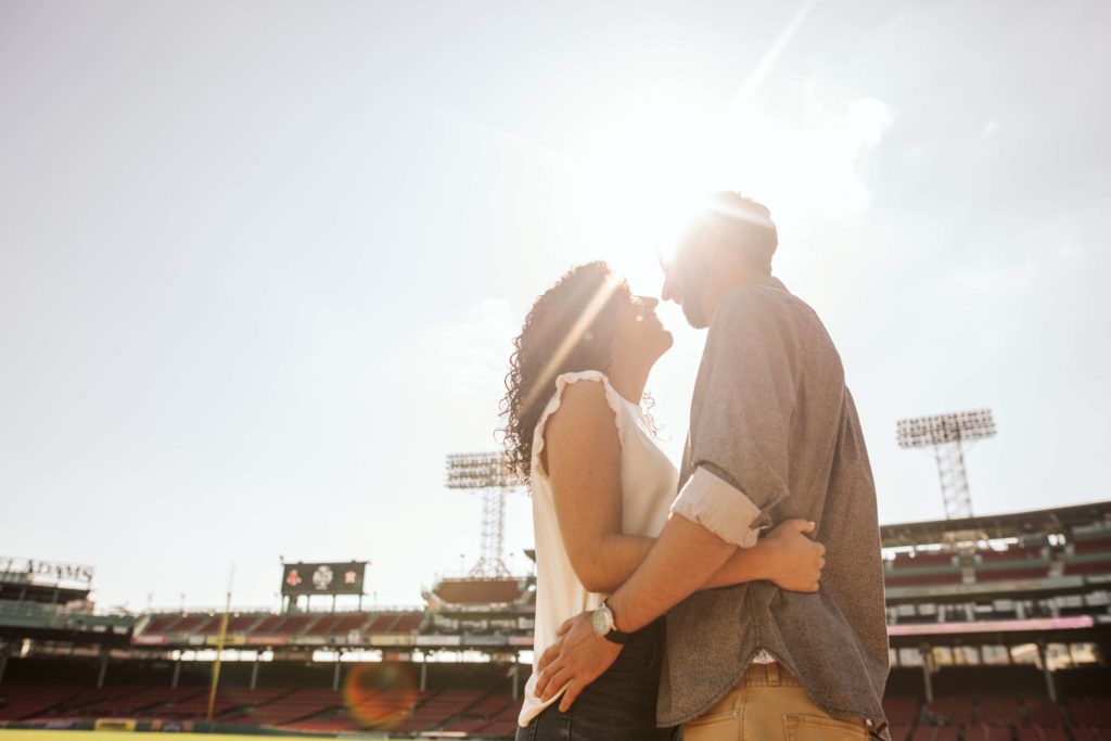 Couple embraces at Fenway Park during their Boston engagement photos